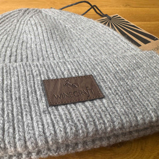 Detailaufnahme der grauen Merino Beanie, plastikfrei verpackt mit nachhaltigem Etikett.